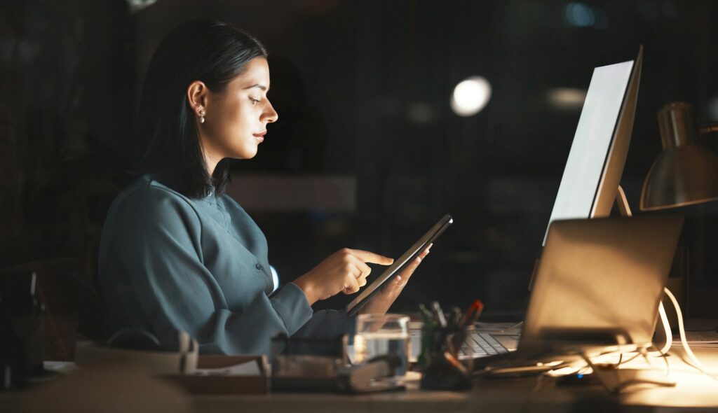 Laptop, computer or business woman on tablet at night in office for research, cloud computing or pl