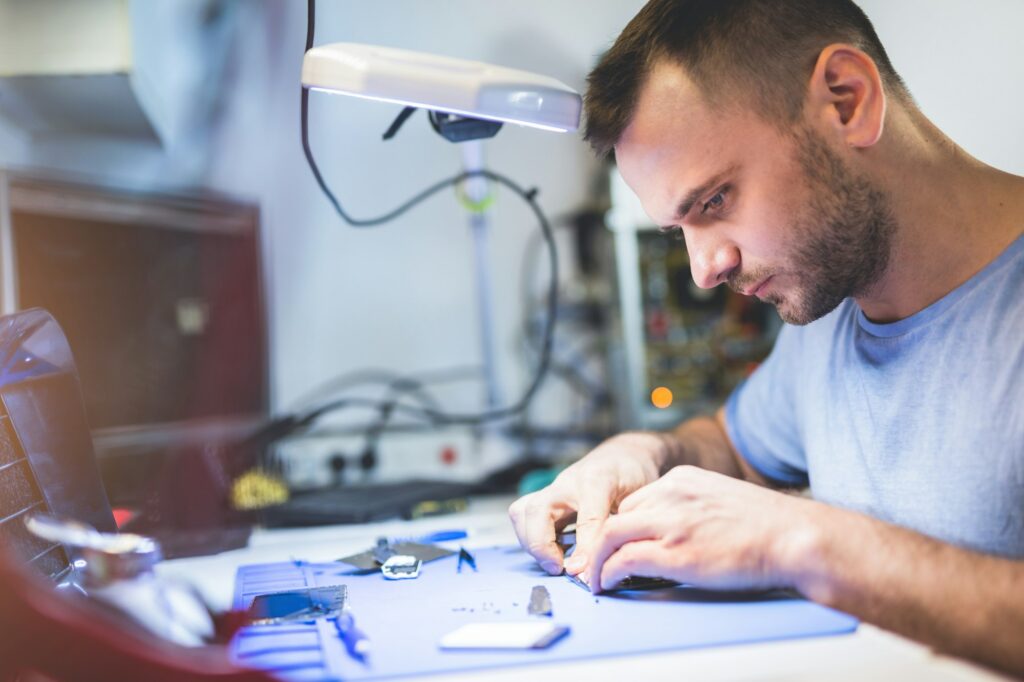 Man repairing smartphone at workplace