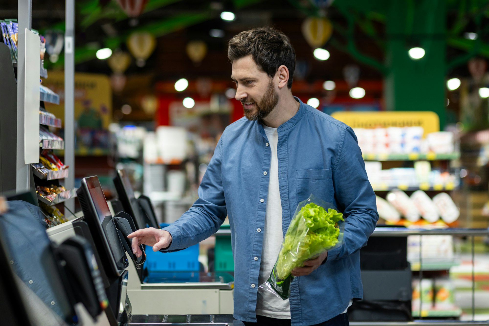 man shopping for groceries at self service checkout