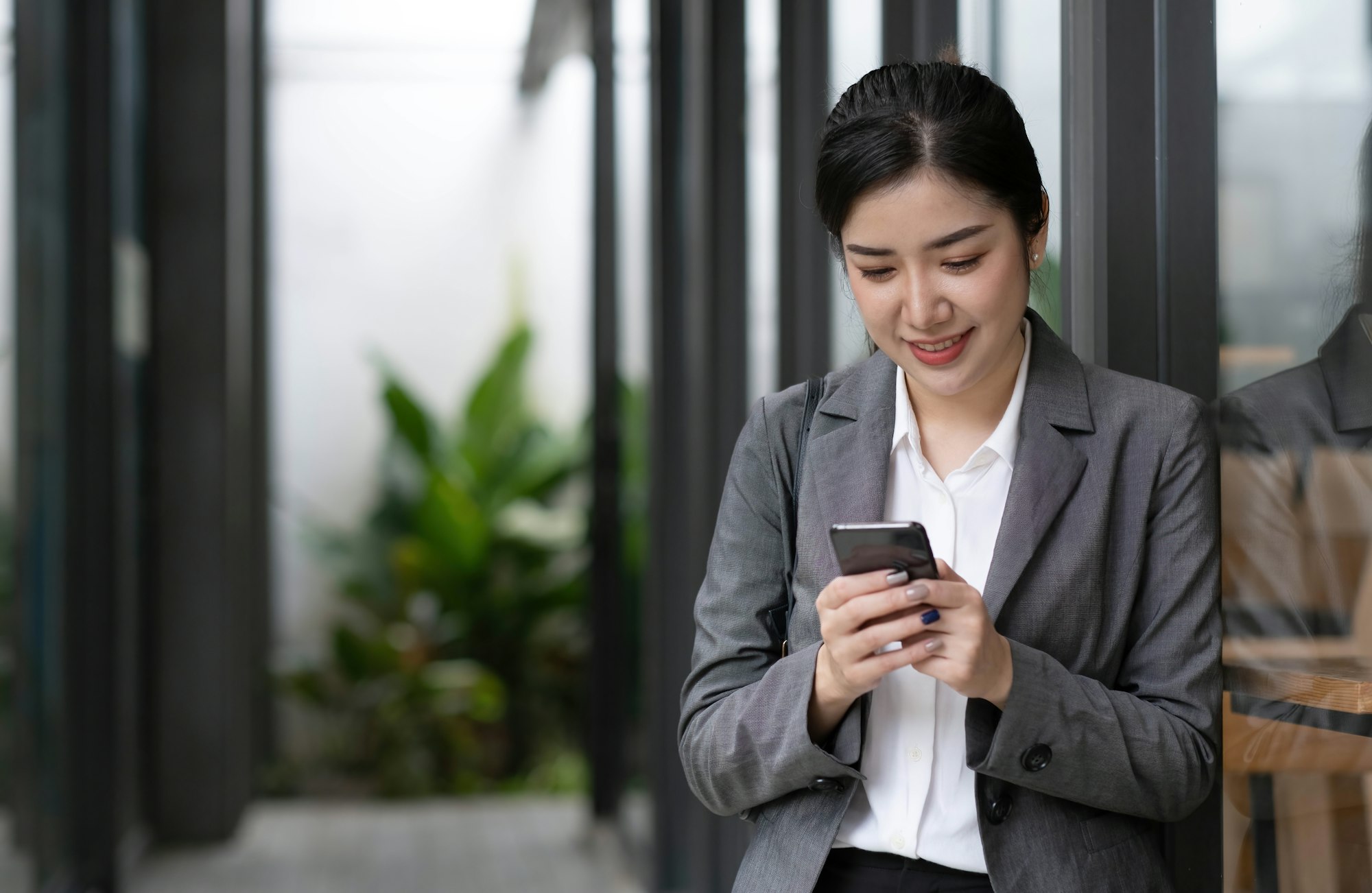 Portrait of a beautiful smiling woman using a mobile phone outdoors