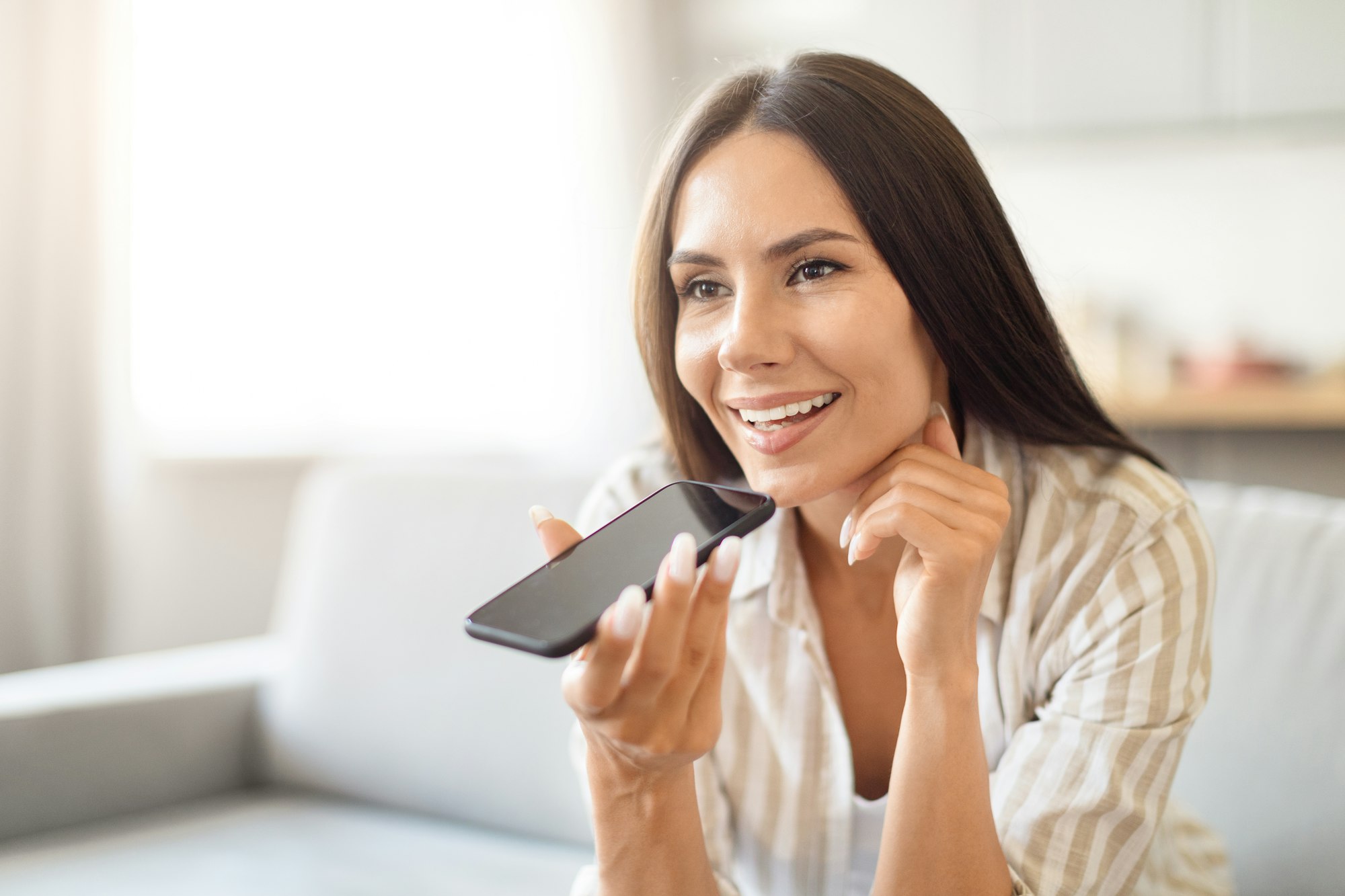 smiling woman holding phone for voice command