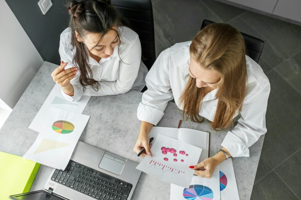 Two women are working in the office. Analysis of the company's financial performance. Office table.