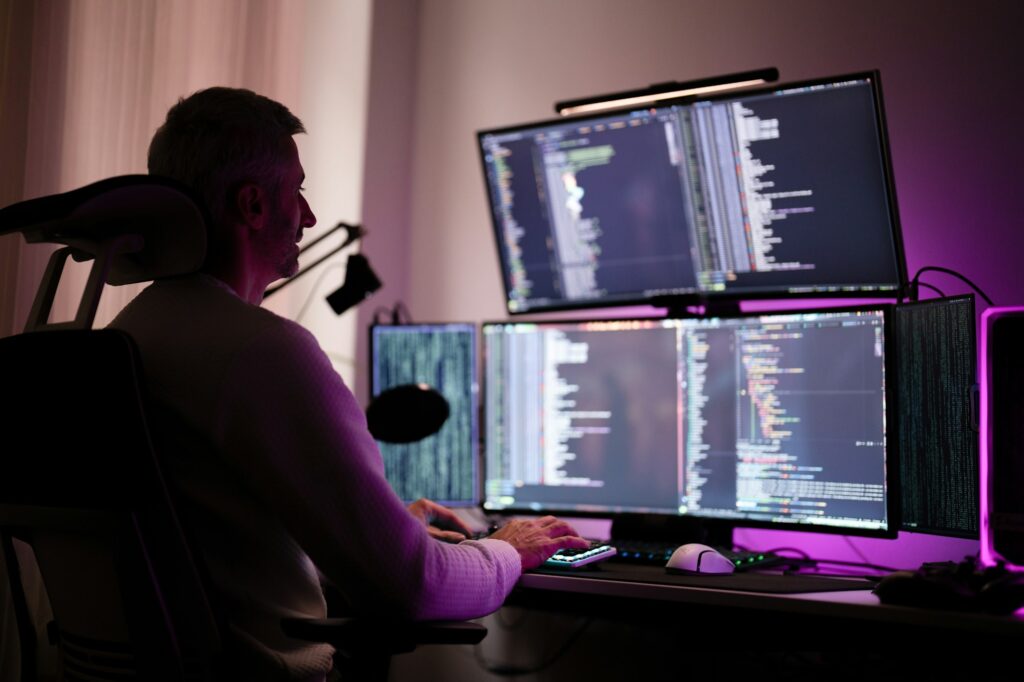 Young contemporary cyber security manager typing in front of computer