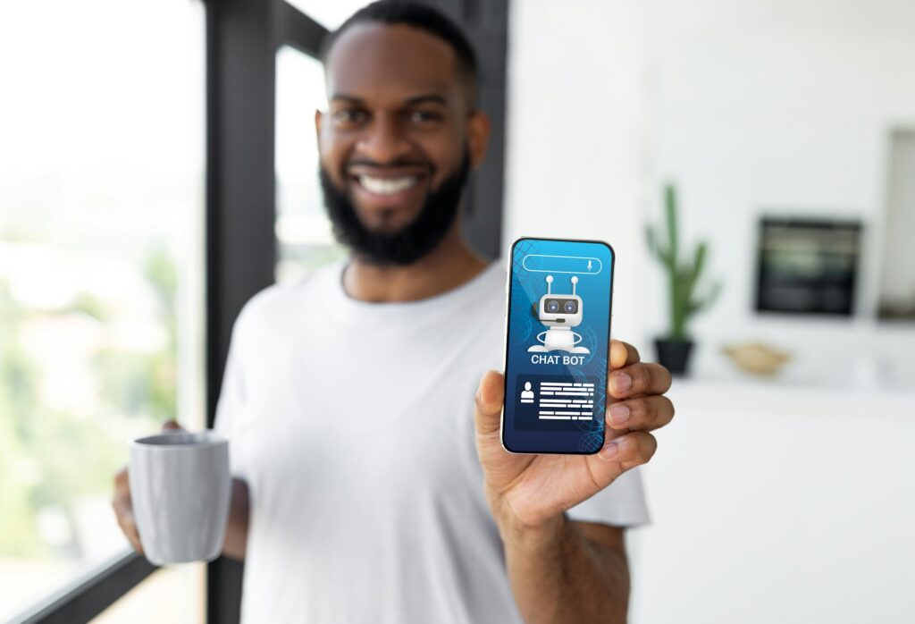 Cheerful black guy showing phone with chatbot screen