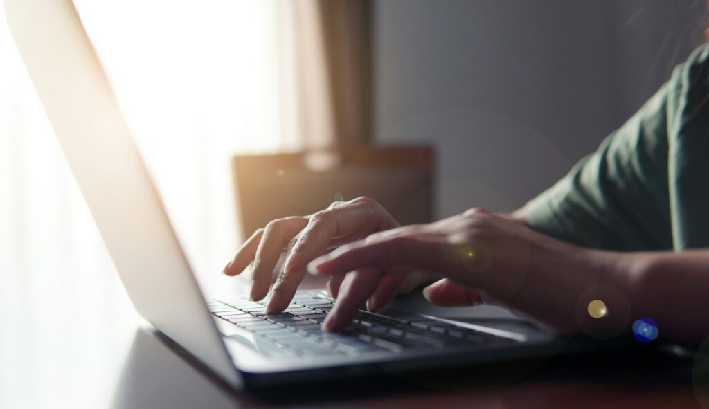 Close up of business people use computer laptop and key data with the sunlight in the morning.