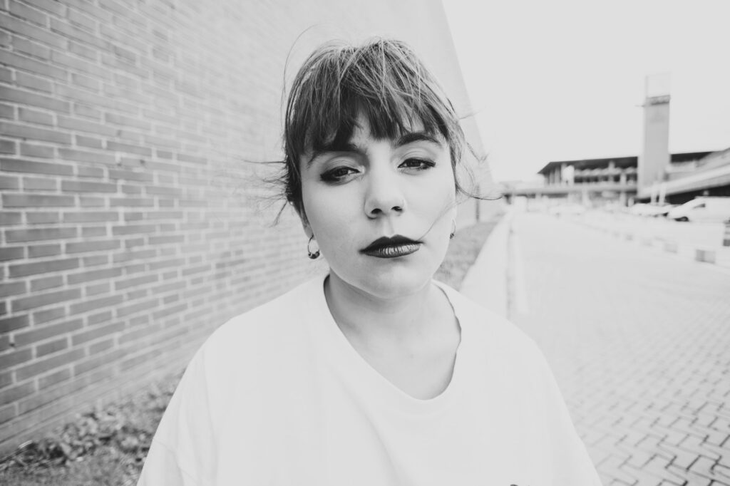 Closeup of a pretty young female with a serious look and a white shirt. Black and white.