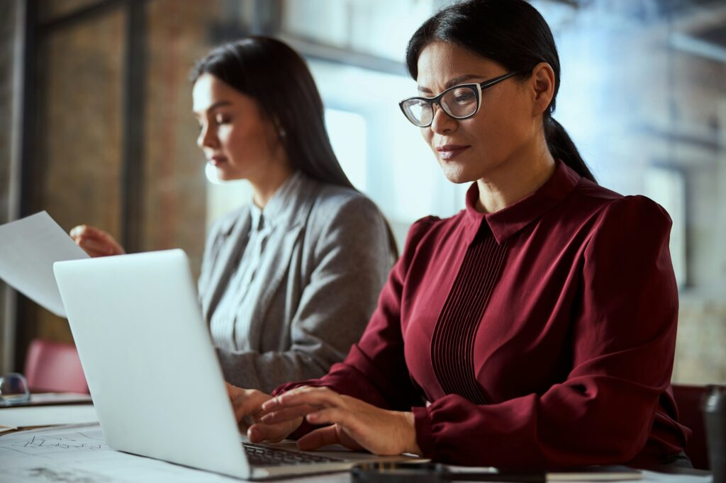 Concentrated Asian woman typing speech for presentation