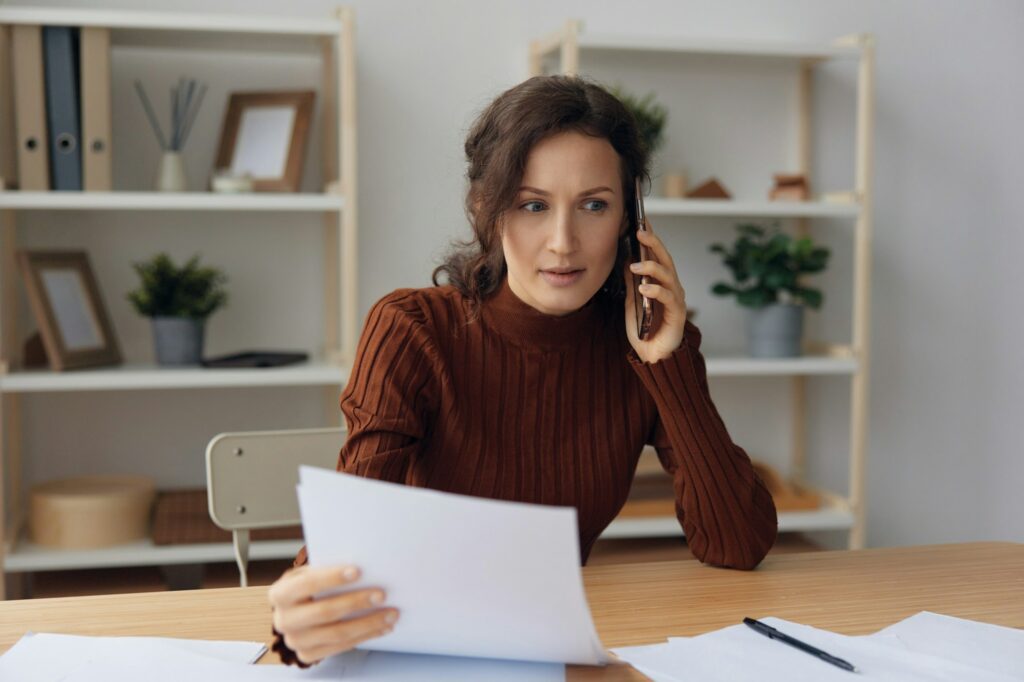 Fake debt notification. Confused angry irritated focused curly lady talk with frauds in call quarrel