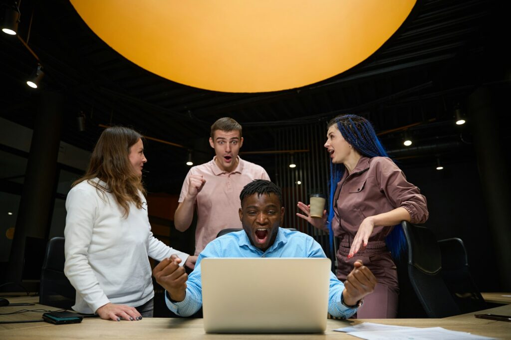 Friendly colleagues spending time in business office betting on sport