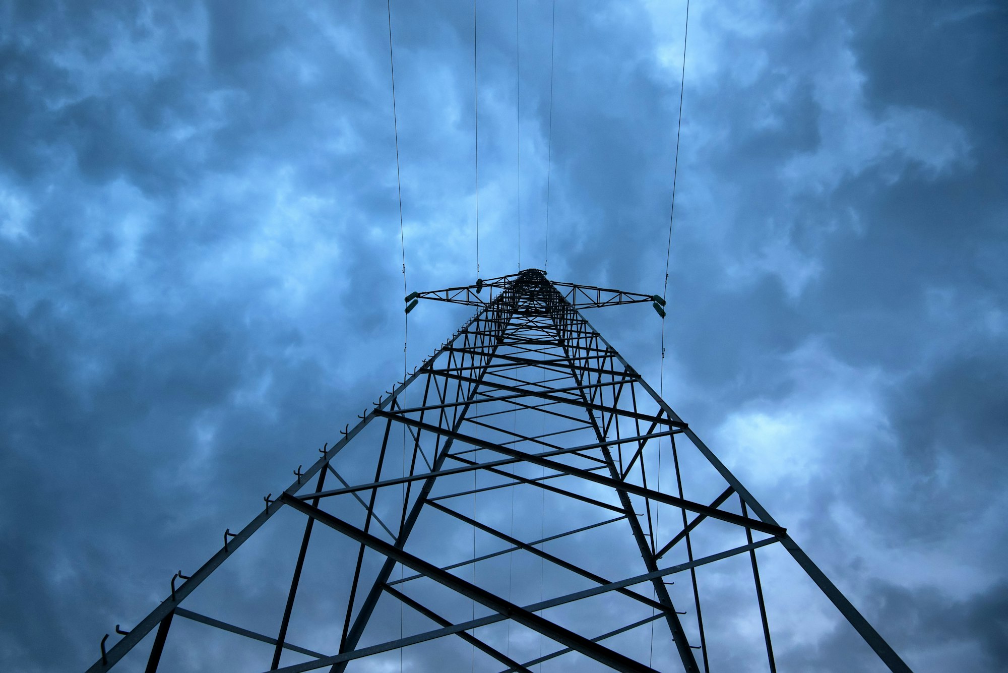 High voltage power pole close against evening sky