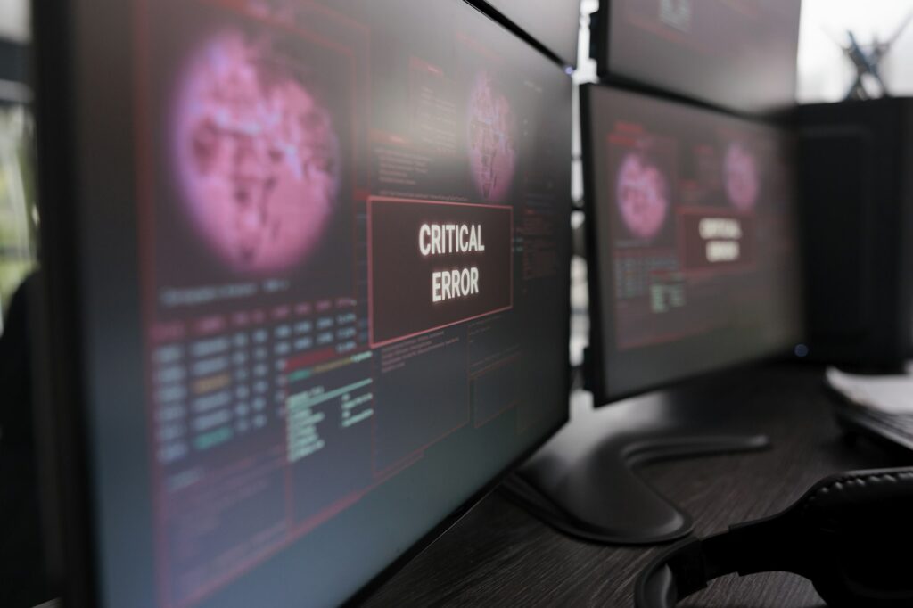 Multiple monitors showing critical error message after cyber crime attack