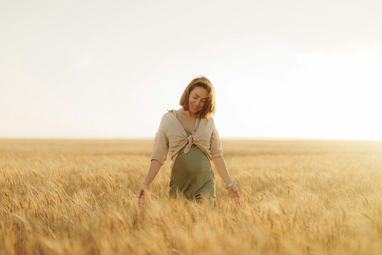 Positive young woman walking through grass field