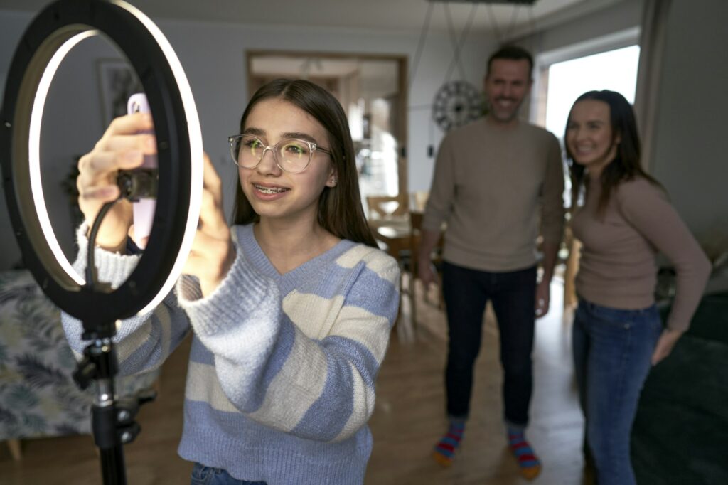 Teenager girl with parents recording dancing for social media