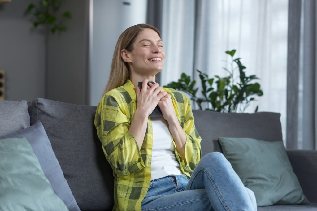 Woman at home happy received the answer, when dating online dating, blonde sitting on the couch