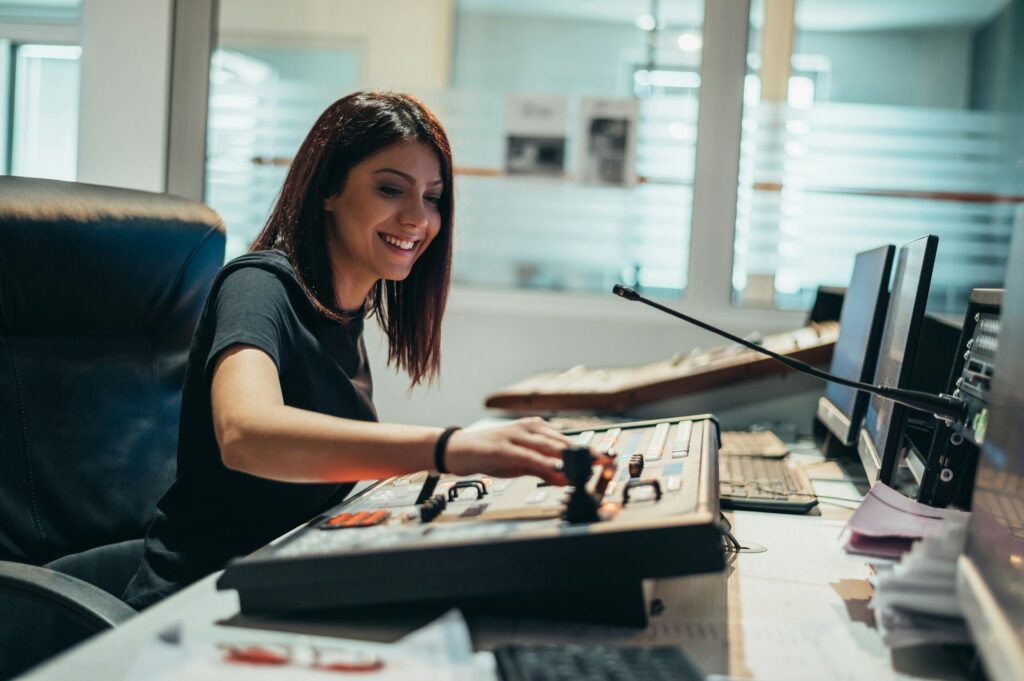 Young beautiful woman working in a broadcast control room on a tv station