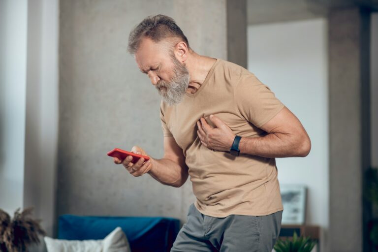 A midaged bearded man having a heart attack