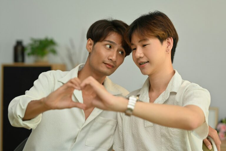 Affectionate same sex male couple making heart with their hands. LGBT concept.