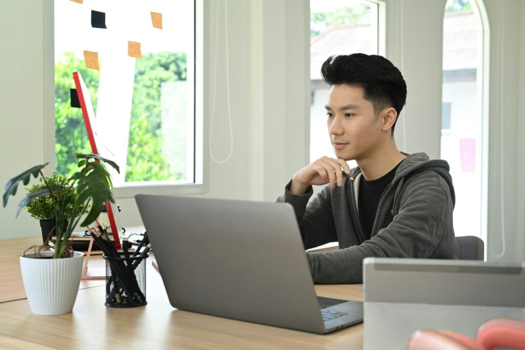 Concentrated creative man working on design project at bright modern office.