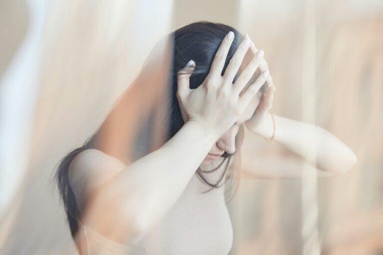 Distorted portrait of young woman struggling with headache