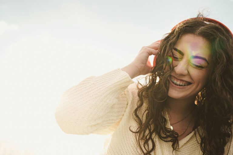 Portrait of a woman with tooth brace listening to the music with headphones