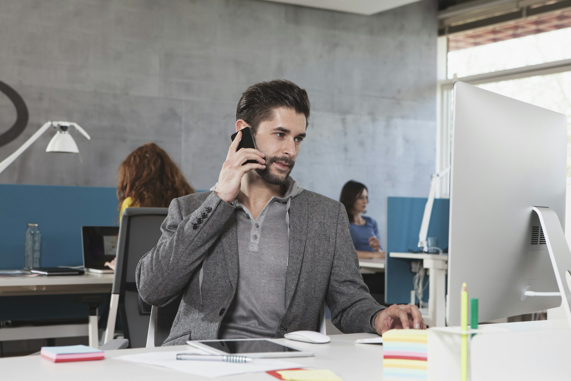 Portrait of man telephoning with his smartphone at his workplace in the office