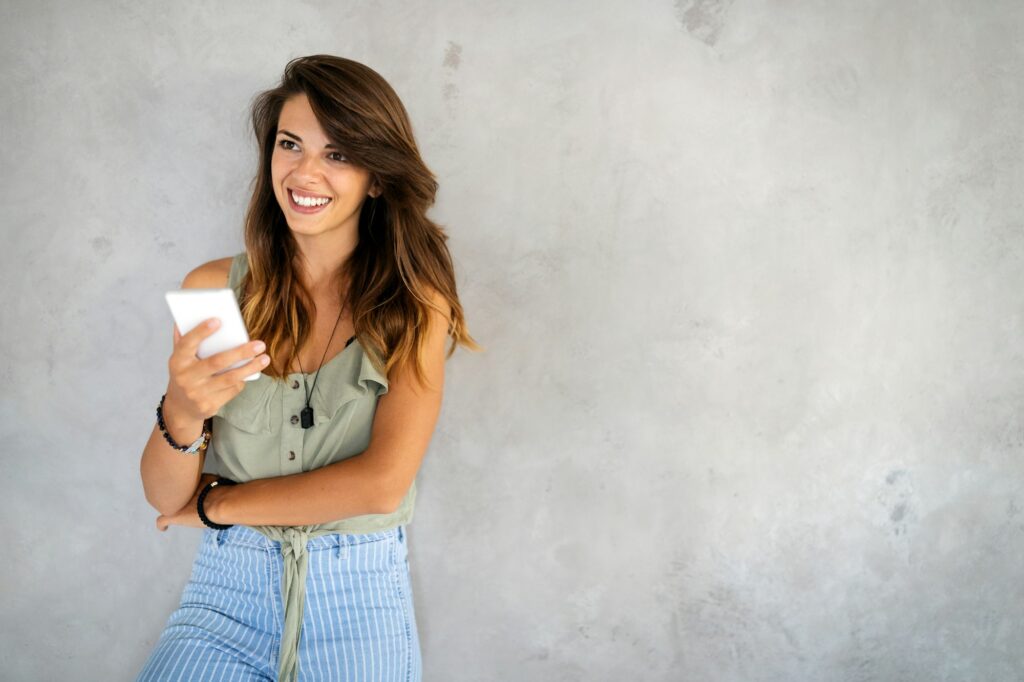 Smiling happy beautiful woman using smartphone. Technology, device people concept