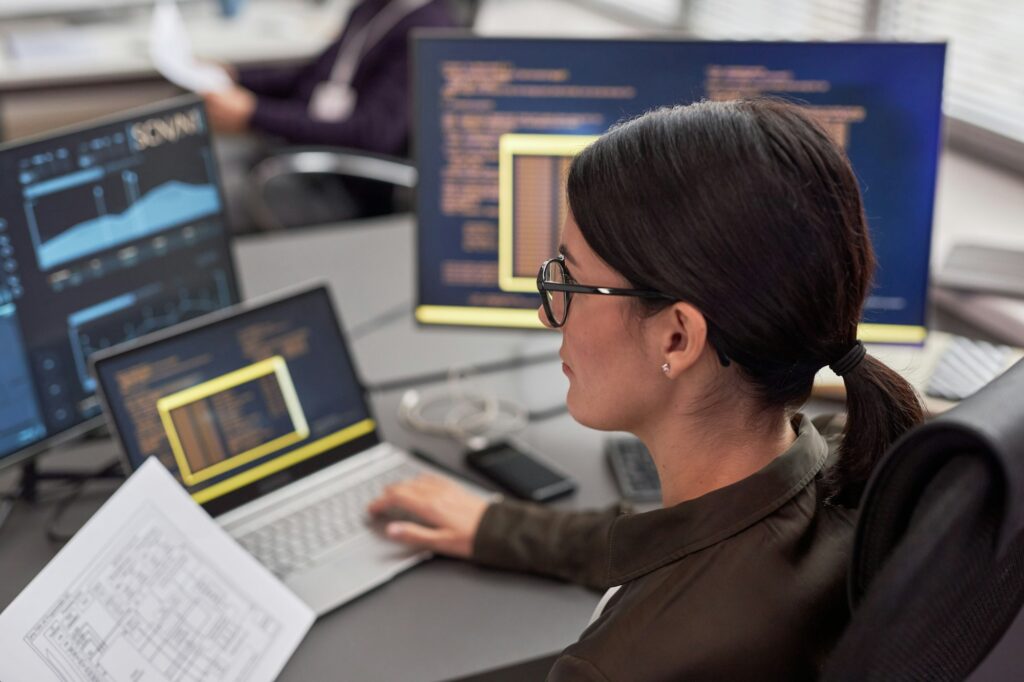 Woman as female IT engineer working with data at desk