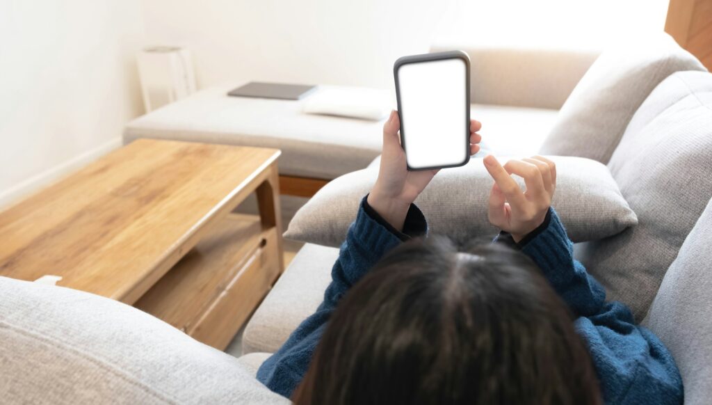 Woman configuring privacy settings on the mobile phone, lying down at home. white screen. "Privacy