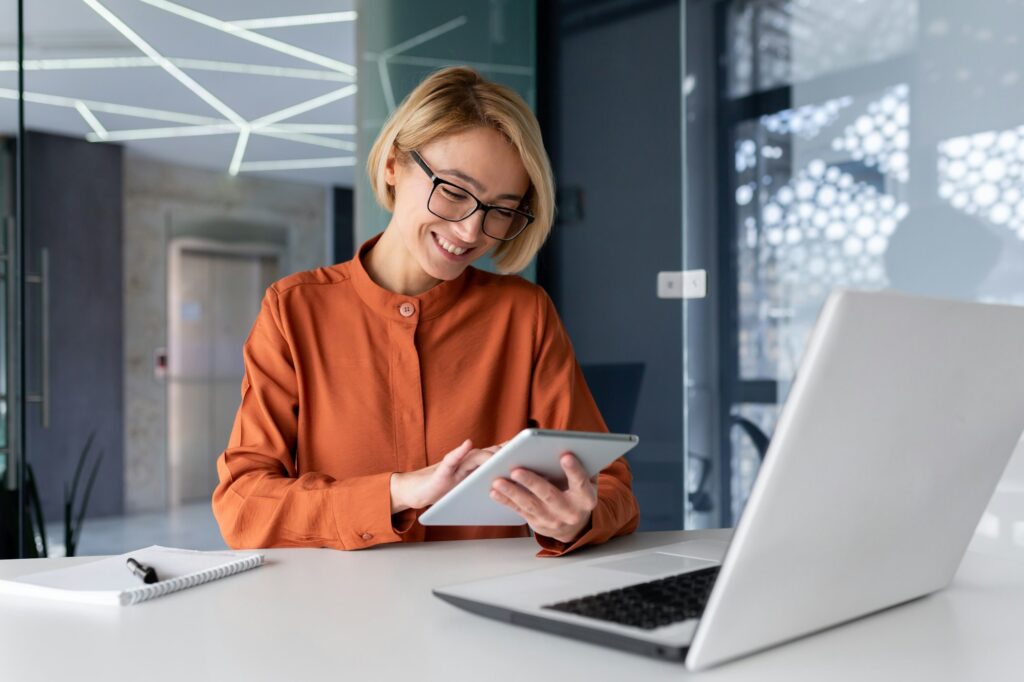 Young successful businesswoman at workplace is satisfied with results of achievement at work