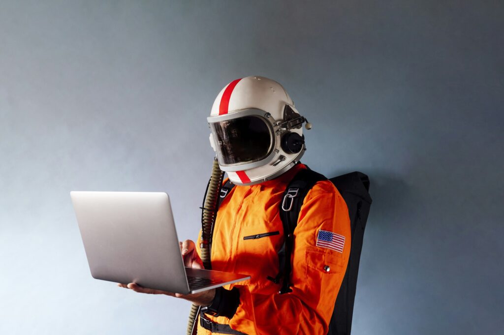 Astronaut in spacesuit works on laptop, High-tech space exploration concept