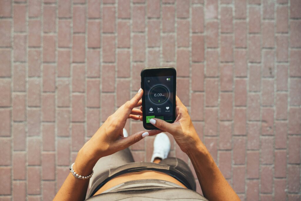 Athlete looking on smartphone with training data on display