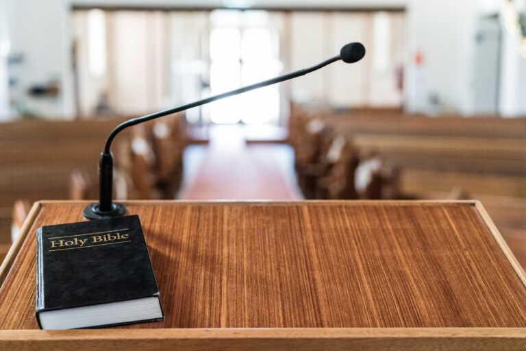 Bible on pulpit in church, with light coming in through the front door