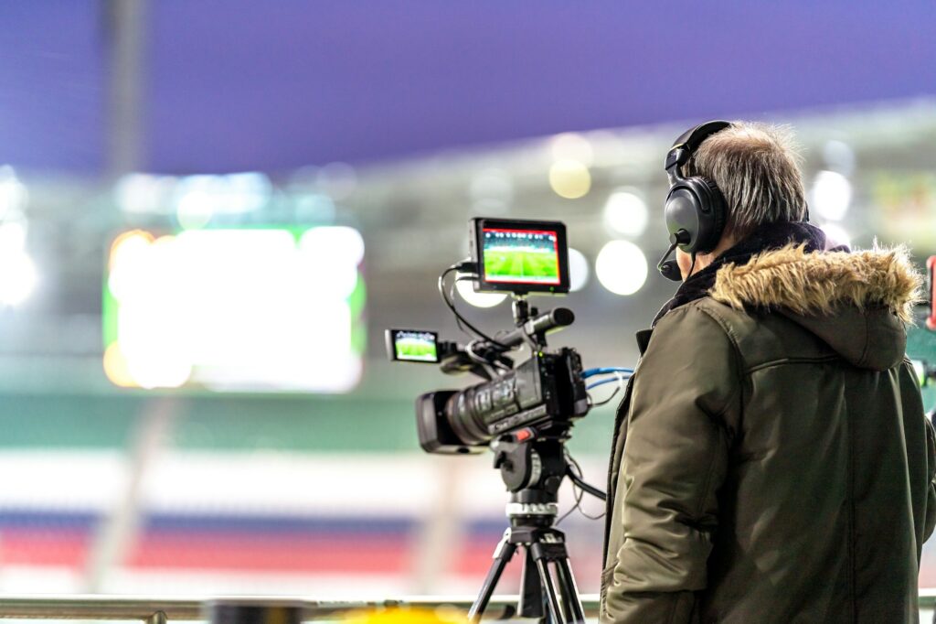 cameraman with a professional video camera on the broadcast of a football match