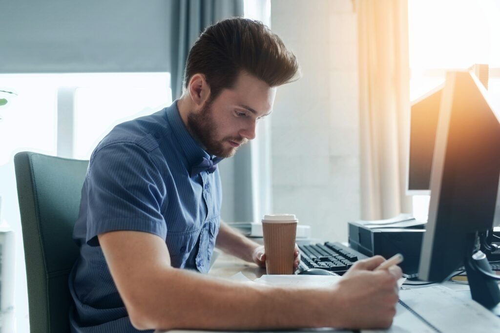 creative male office worker with coffee writing