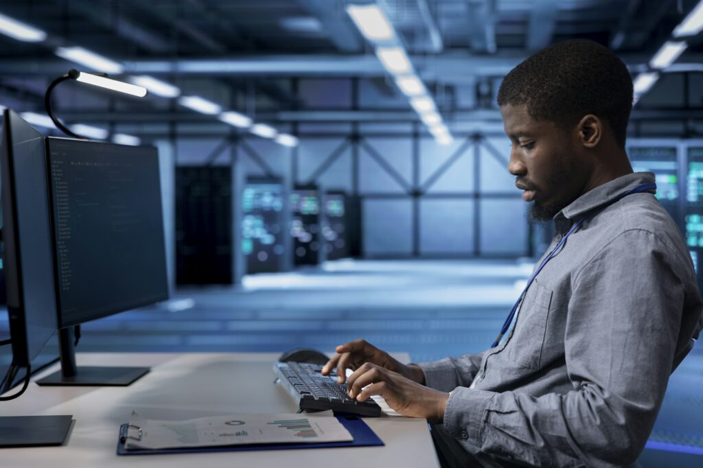 Employee checking for signs of tech failure in data center supercomputers