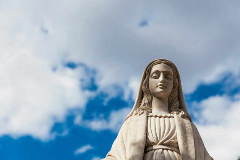 Marble figure of the Virgin Mary. Blue sky background.