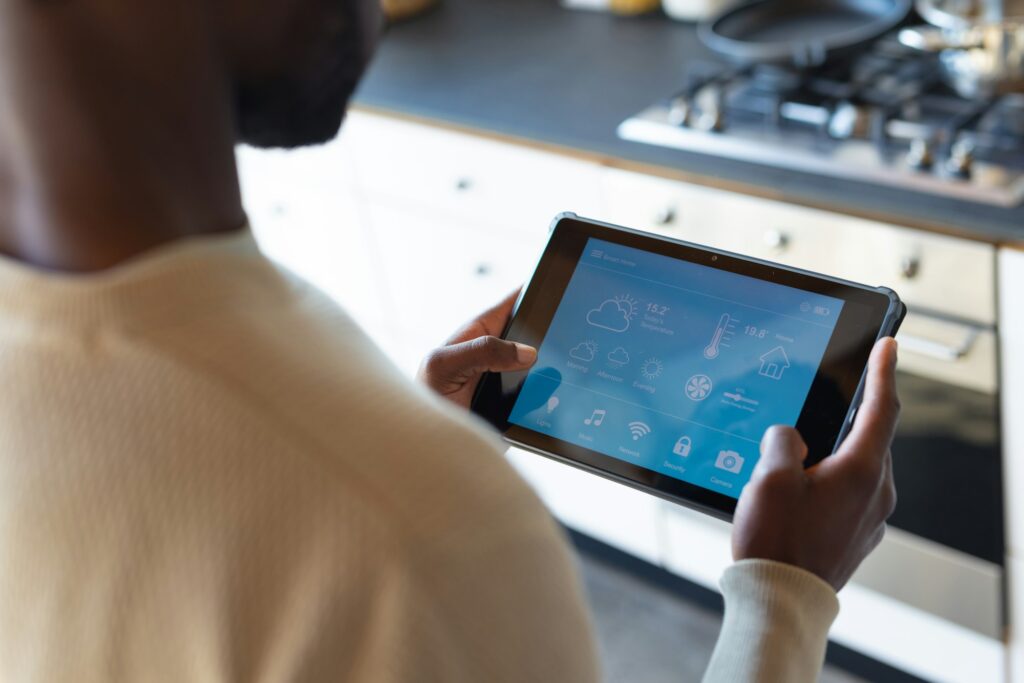 Midsection of african american man using tablet with weather forecast