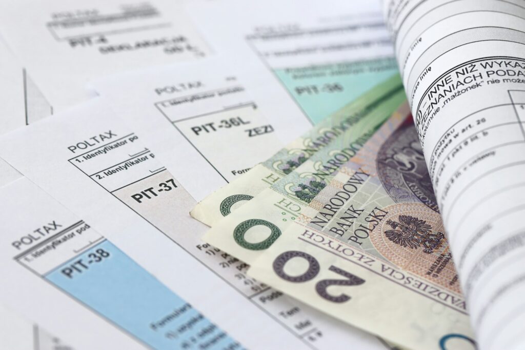 Polish zloty money on big amount of polish tax forms close up