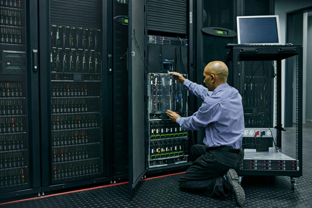 Shot of an IT technician repairing a computer in a data center