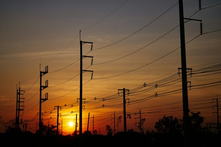 The electric poles and electric lines with a sky of sunset