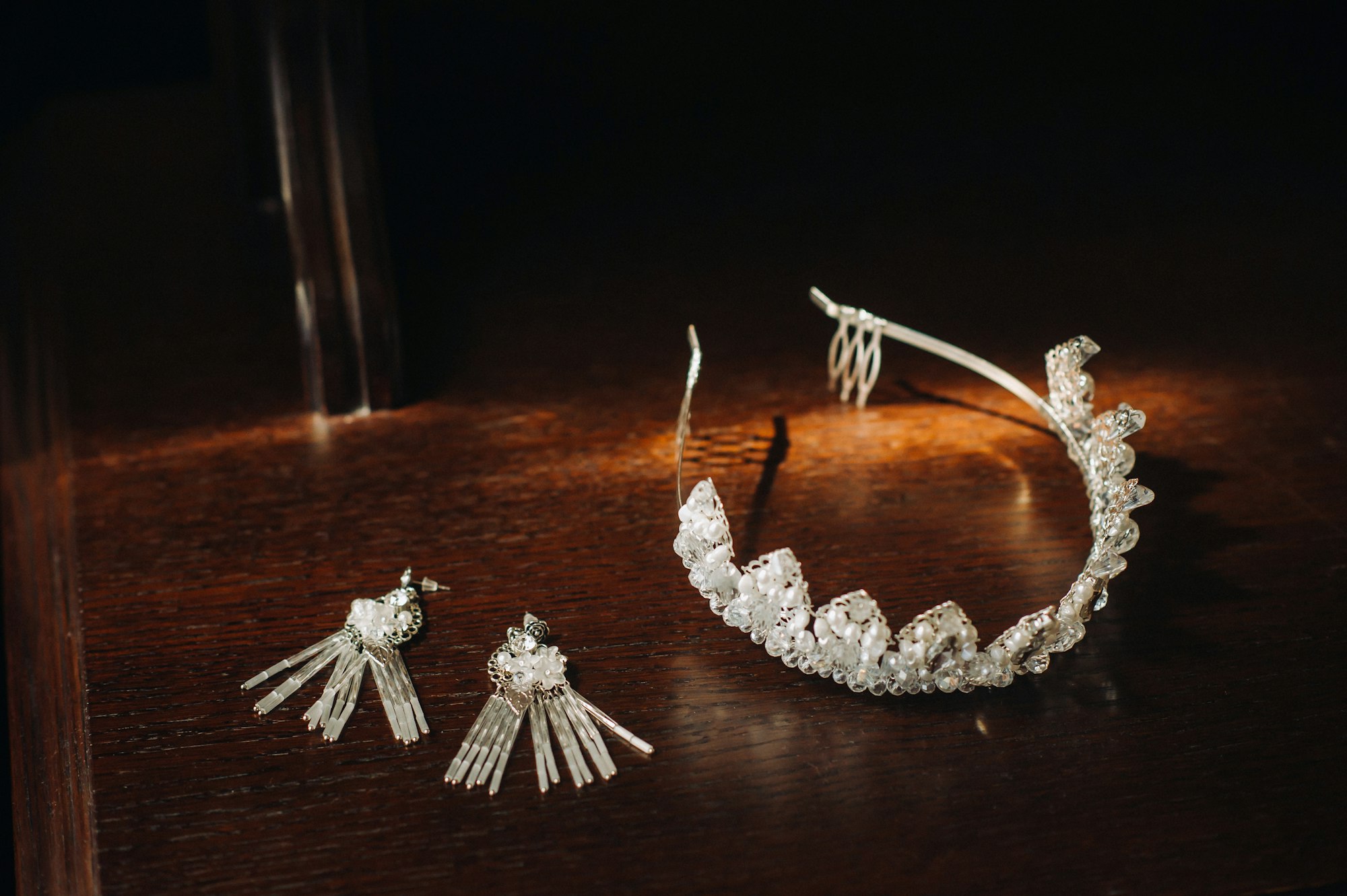 Wedding crown for the bride and earrings lie on the trellis