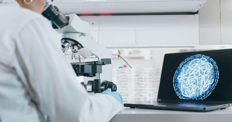 Woman, scientist and laptop with microscope in laboratory, microbiology and research study of organ