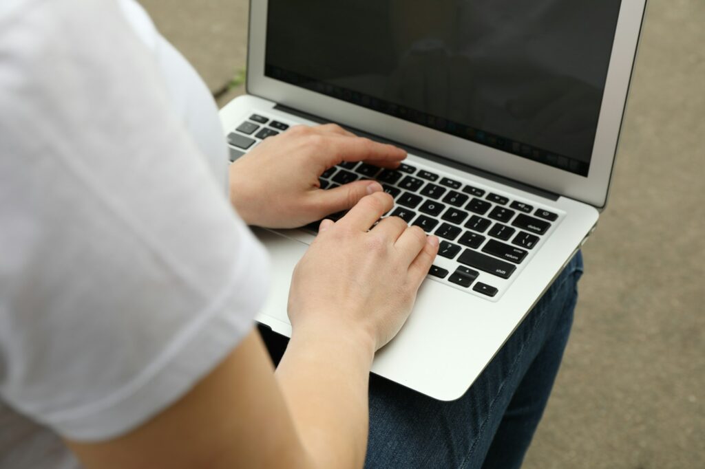 Woman with laptop works in park. Outdoor work