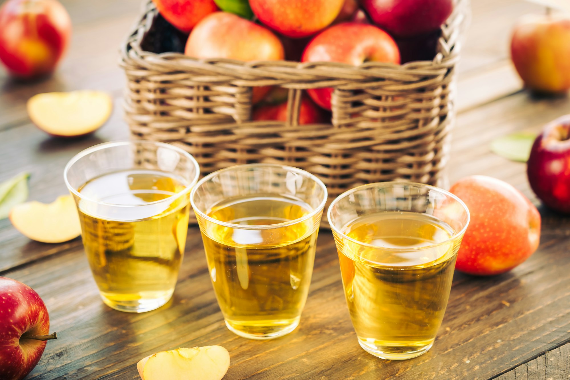 Apples juice in glass with apple in the basket