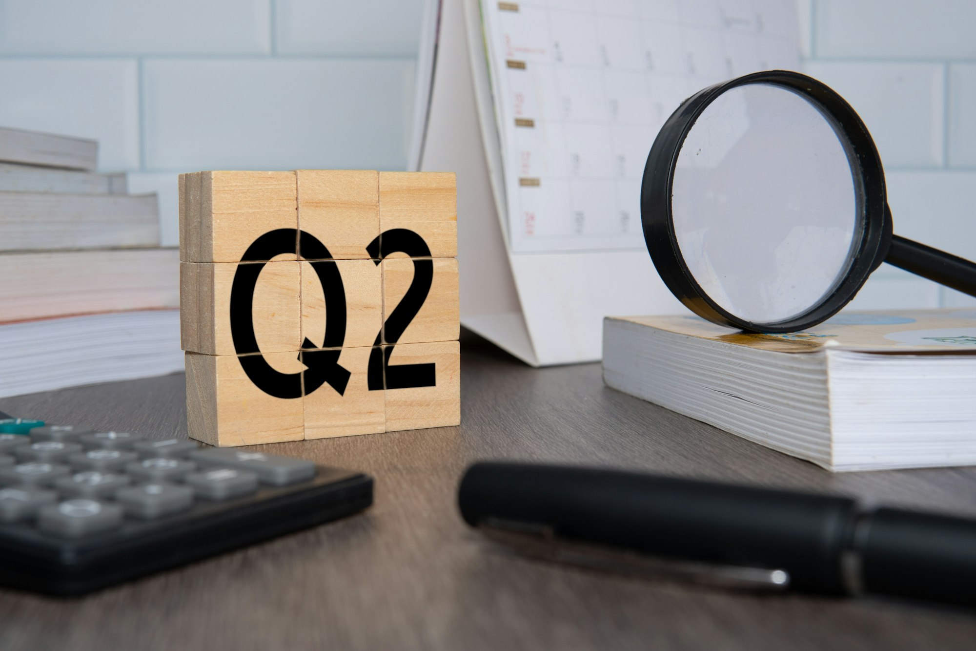 Close up image of wooden cubes with alphabet Q2 on office desk.