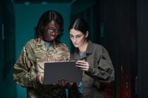 Female IT Technicians Using Laptop in Server Room