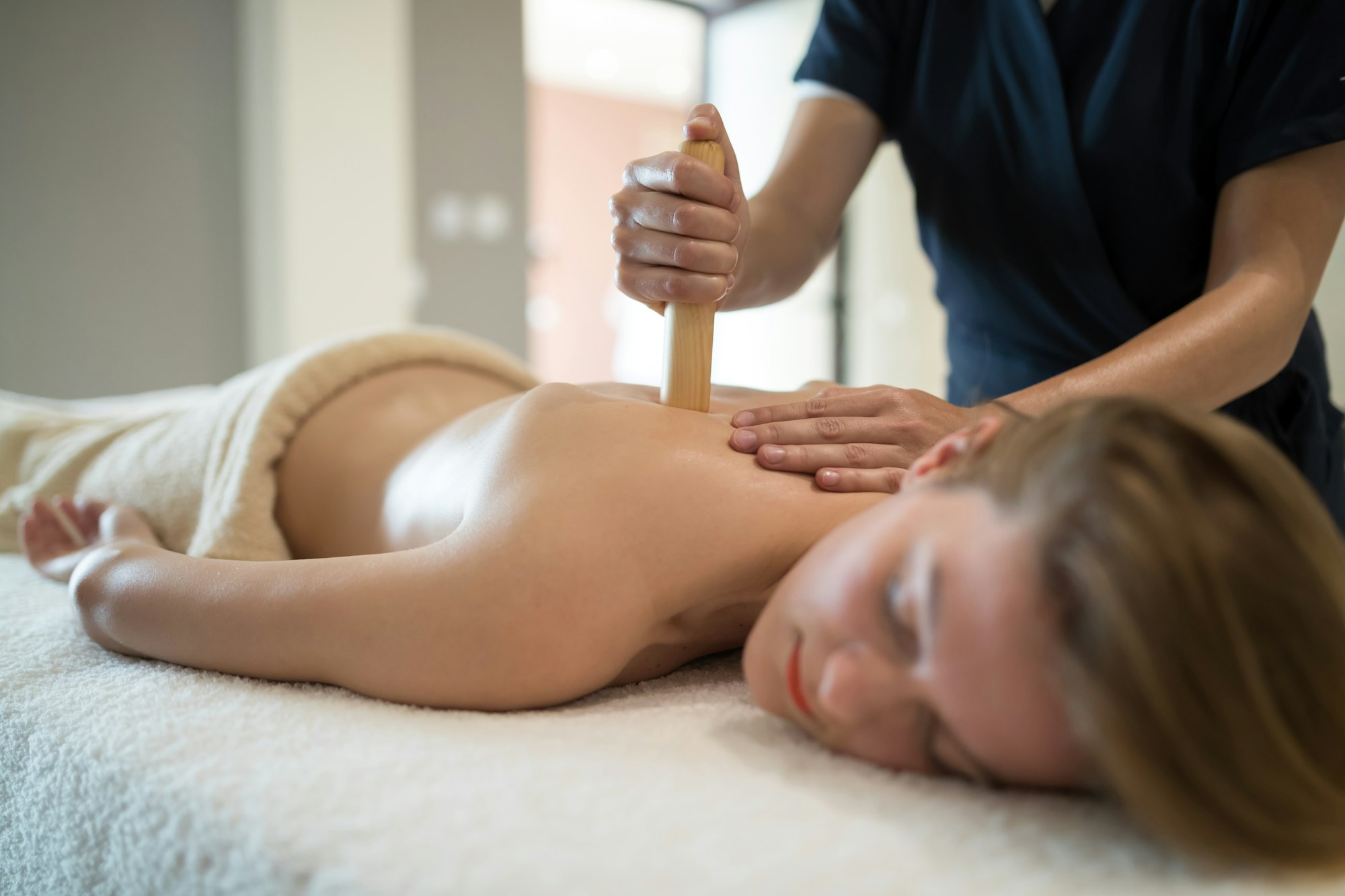 Masseur treating patient with therapeutic massage