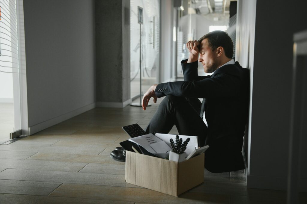 Sad Fired. Let Go Office Worker Packs His Belongings into Cardboard Box and Leaves Office.