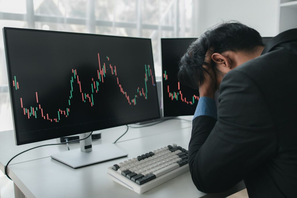 Stock investor with stock market graph screen, he stressed, stock market volatility analysis, busine