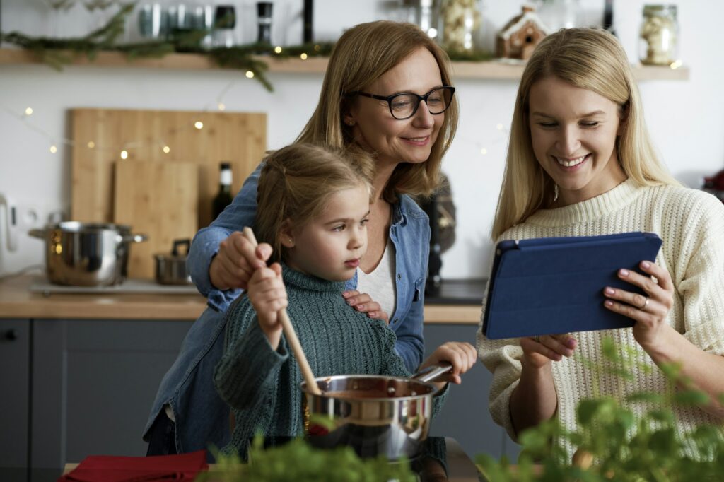 Three generations of women looking for recipe on the tablet